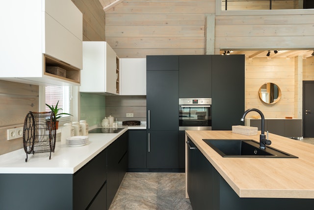kitchen with dark blue cabinets, white counters and light wood wall details